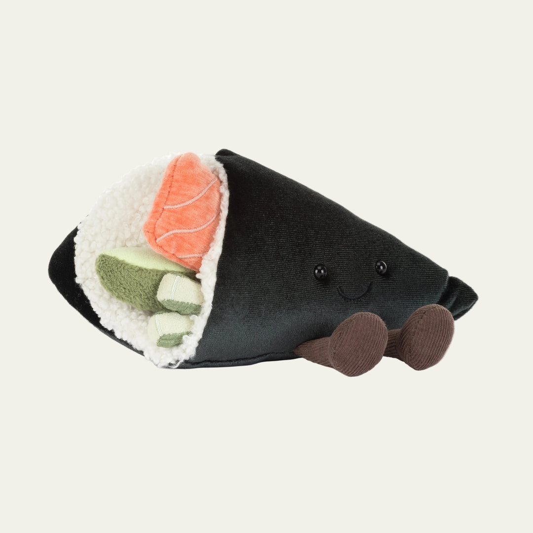 Stuffed toy resembling a sushi roll with black exterior, orange and green fillings on a white background