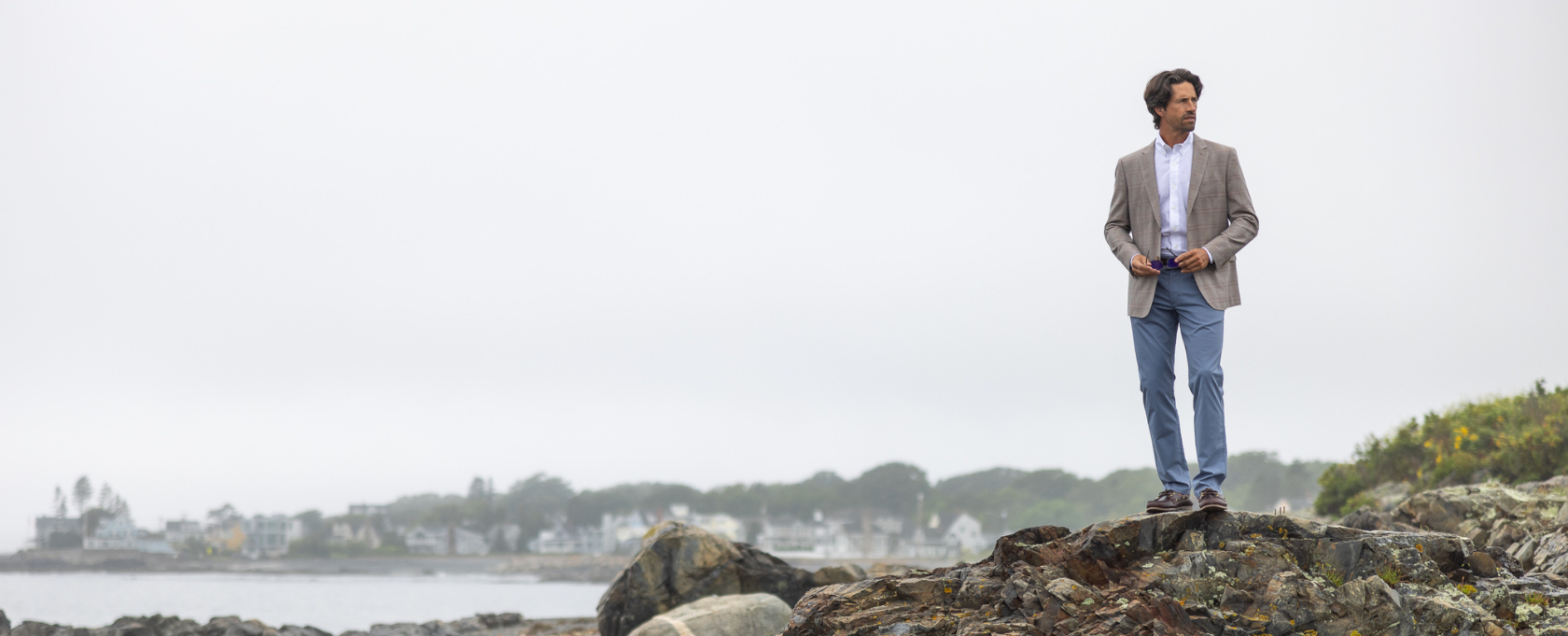 Man standing on rocks by the coastline